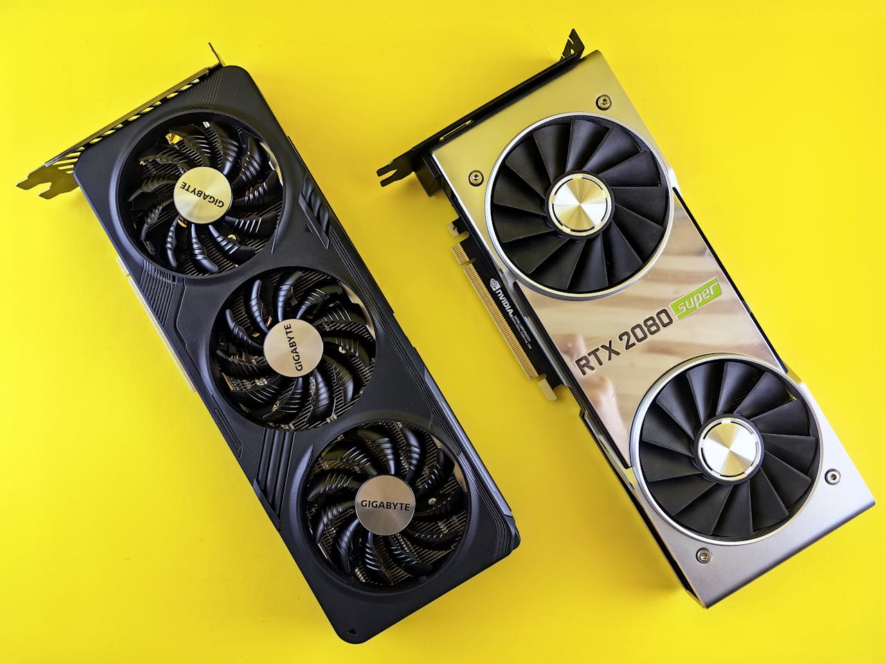 Two high-performance graphics cards displayed on a bright yellow background.