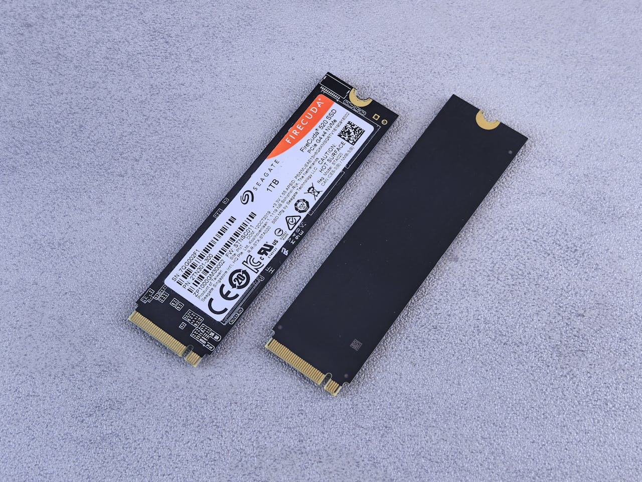Two NVMe SSDs, Seagate FireCuda, on a gray background for tech enthusiasts.